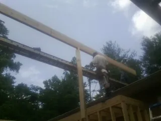 Carpenter setting a ridge beam over a new addition frame — Ice Dam Removal by Roofing Brothers in Shorter