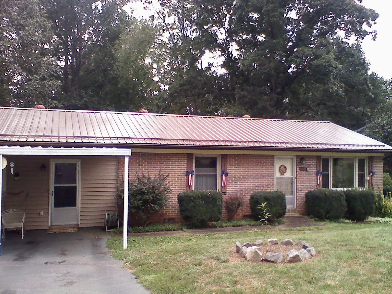 Bronze metal roof and carport on a brick ranch home — Roof Repair work by our crew in Shorter