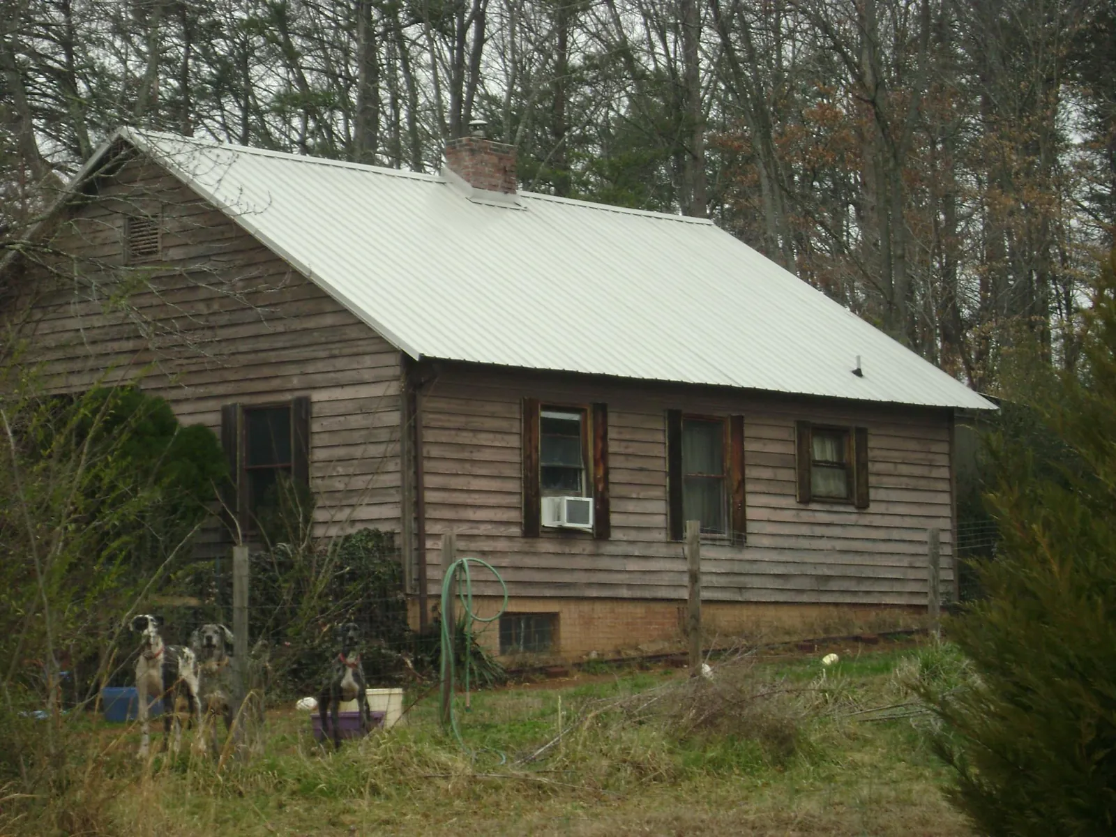 White metal roof on an old wood sided farmhouse, from a Metal Roof Installation job in Shorter